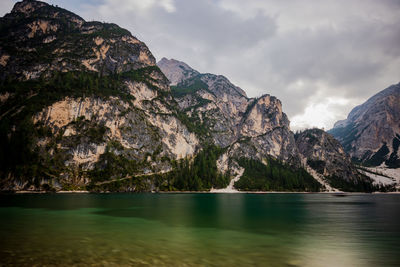 Scenic view of sea and mountains against cloudy sky