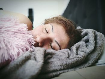 Close-up of woman sleeping on bed at home