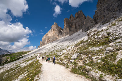 People walking on mountain against sky