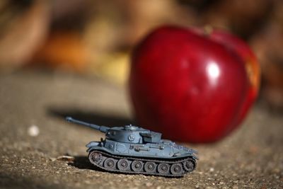 Close-up of armored tank against apple on footpath