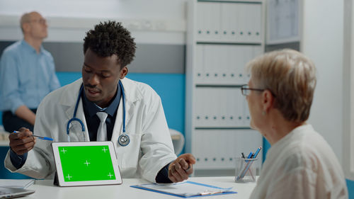 Doctor showing digital tablet to patient