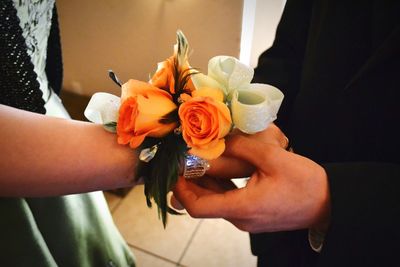 Midsection of couple holding bouquet