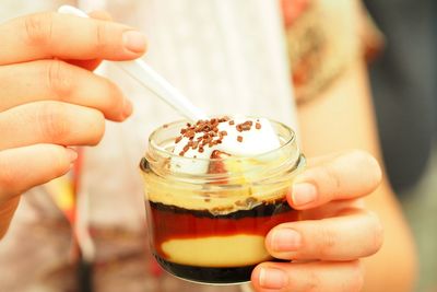 Close-up of hand holding dessert in bowl
