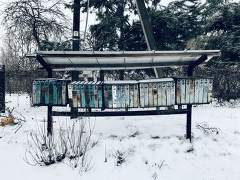 Empty bench on snow covered field during winter