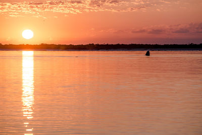 Scenic view of sea against orange sky