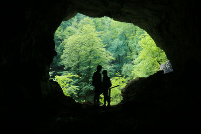 Silhouette couple standing in cave