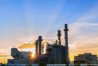 Factory against sky during sunset