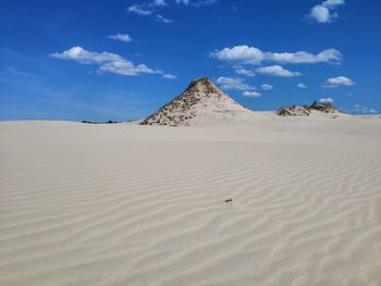 Sand dunes in desert against sky