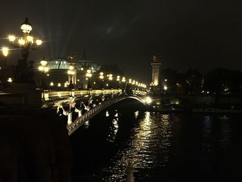 Illuminated city against sky at night