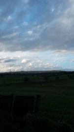 Scenic view of field against cloudy sky