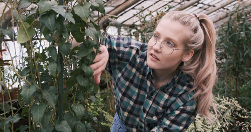 Portrait of young caucusian woman with plants in farm