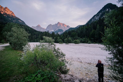 Rear view of man photographing mountains