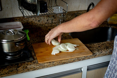 Hands cutting onion into slices. healthy seasoning.