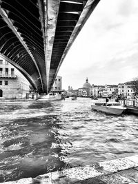 Bridge over river in city against sky