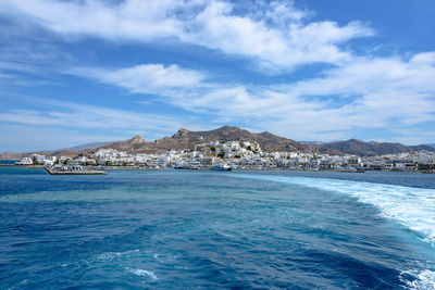 Scenic view of sea by buildings against sky