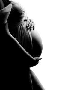 Midsection of woman with arms raised against white background