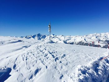 Scenic view of snowcapped mountains against blue sky on sunny day