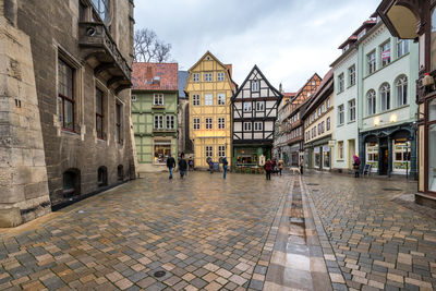 People on street amidst buildings in town