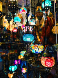 Illuminated lanterns hanging in store for sale