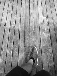 Low section of woman standing on wooden floor