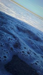 Close-up of wave on beach against sky