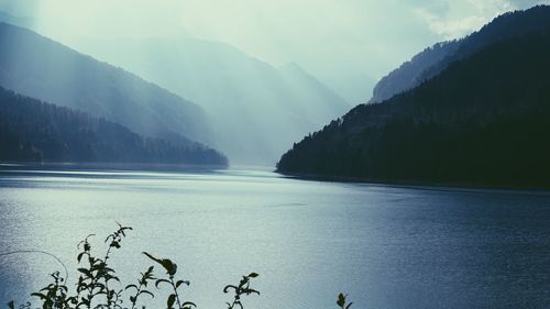 Scenic view of lake by mountains against sky