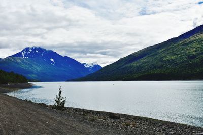 Scenic view of lake by mountains against sky