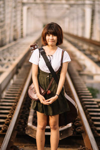 Portrait of woman standing on railroad track