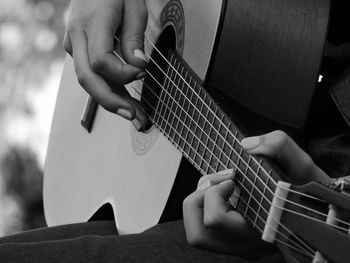 Midsection of man playing guitar