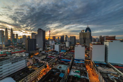 Modern buildings in city against sky during sunset