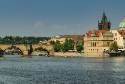 Arch bridge over river against buildings in city