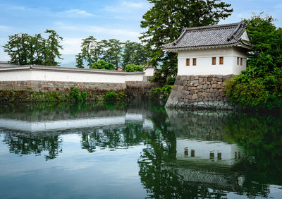 Building by lake against sky