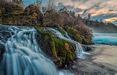 Scenic view of waterfall against sky