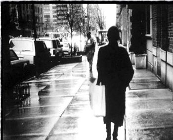 Rear view of man walking on wet street