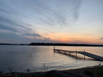 Pier over lake against sky during sunset