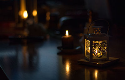 Close-up of illuminated lantern on table at night