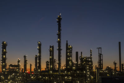 Illuminated factory against sky at night