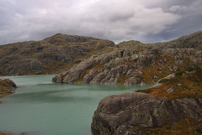 Scenic view of mountains and sea against cloudy sky