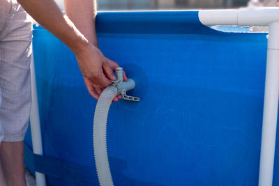 Midsection of man working in blue container