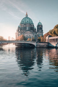 View of berlin cathedral reflected in river against clear sky