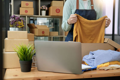 Midsection of woman using laptop on table
