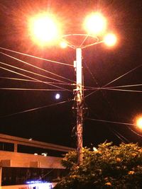 Low angle view of illuminated street light against sky