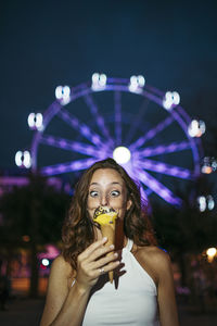 Portrait of woman holding carousel at amusement park