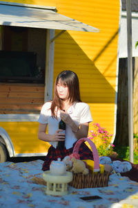 Portrait of young woman sitting on table