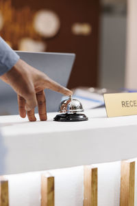 Cropped hand of woman using laptop on table