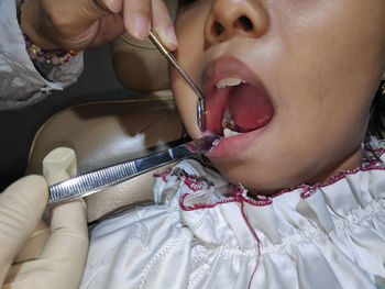 Close-up of dentist examining girl teeth