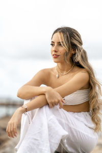 Portrait of young woman sitting on beach