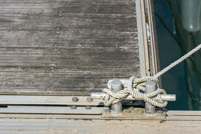 Close-up of rope tied to cleat at harbor