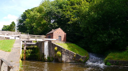 Old bridge over river against sky