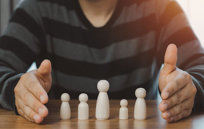 Close-up of man holding hands on table